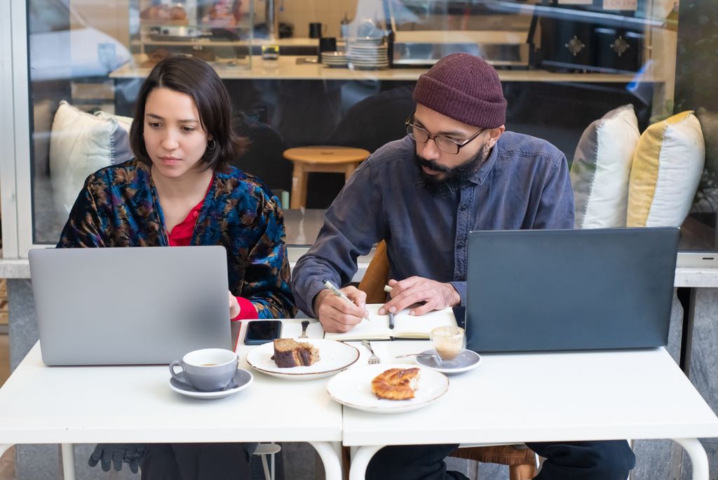 Business meeting over coffee with laptops in a cozy café. Collaboration and teamwork at a modern café table.