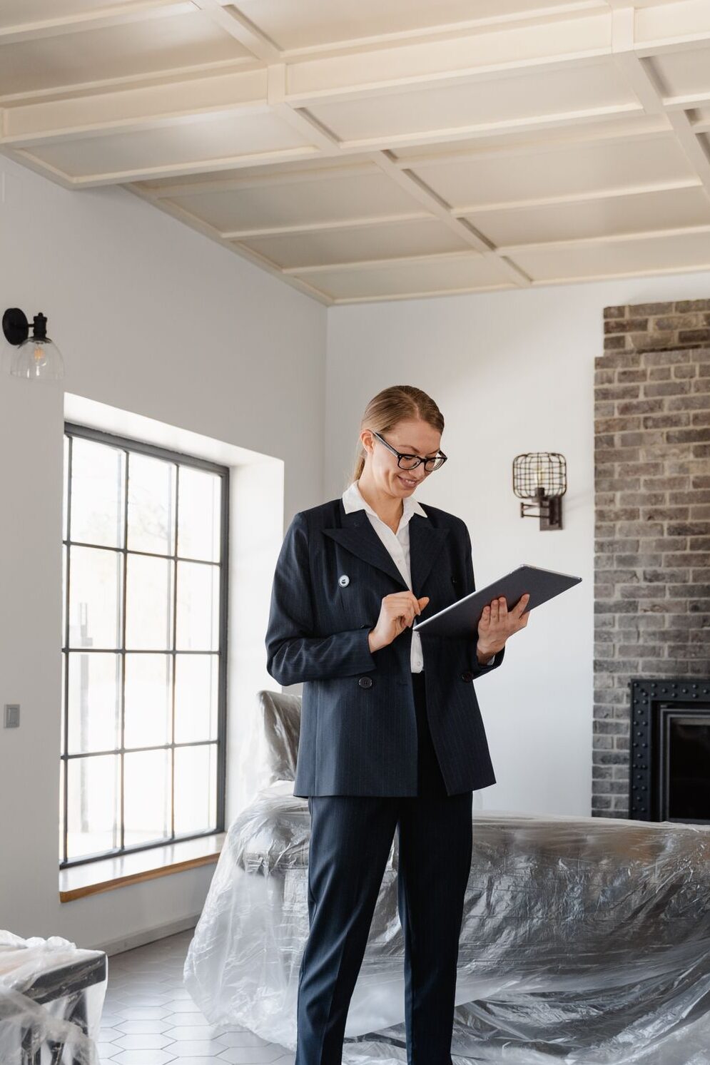 Real estate agent in a suit reviewing paperwork inside a newly renovated home.