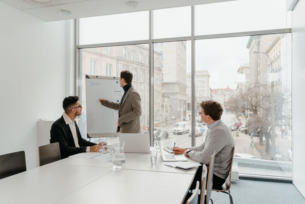 Three professionals engaged in a business meeting in a bright conference room.
